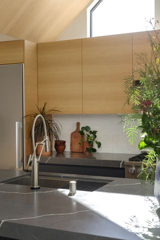Detail of kitchen with stone top island at the Curson Residence by Nwankpa Design