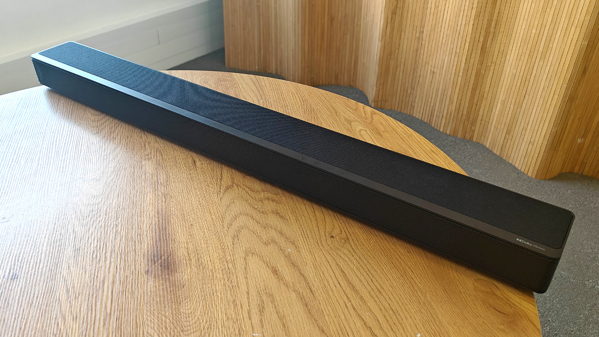 The Hisense AX5125H Dolby Atmos soundbar system, pictured on a round, wooden table