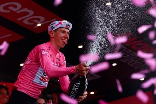 Team UAE's Slovenian rider Tadej Pogacar celebrates the overall leader's pink jersey on the podium of the 11th stage of the 107th Giro d'Italia cycling race, 207km between Foiano di Val Fortore and Franca Villa al Mare, on May 15, 2024. (Photo by Luca Bettini / AFP)