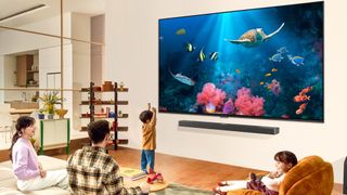 LG QNED TV for 2024 in 98-inch size with family watching in living room 