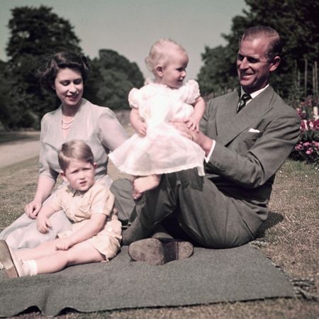 Queen Elizabeth and Prince Philip sitting on a blanket with Princess Anne and Prince Charles at Balmoral