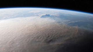 A large cloud of brownish gray smoke on Earth as visible from space