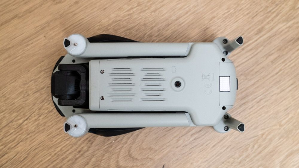 Underneath of a Ruko F11PRO 2 drone folded on a wooden surface