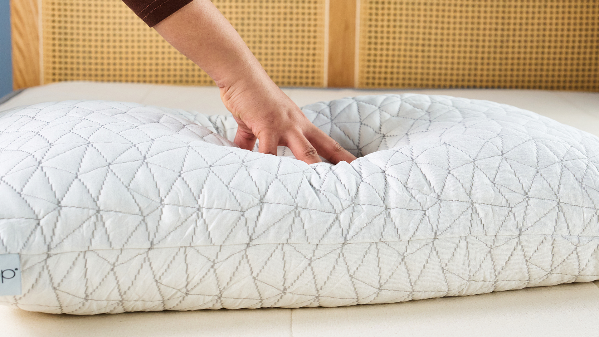 A Tom's Guide tester placing their hand on the Coop Original Adjustable white pillow