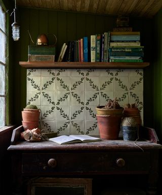 A kitchen dresser with a tile mural backsplash