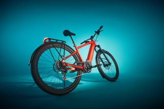 The red Specialized Tero X electric bike is shown in full with a blue background