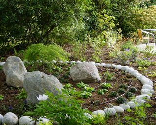 stone circle in a flower bed made from small rocks with larger boulders in the center