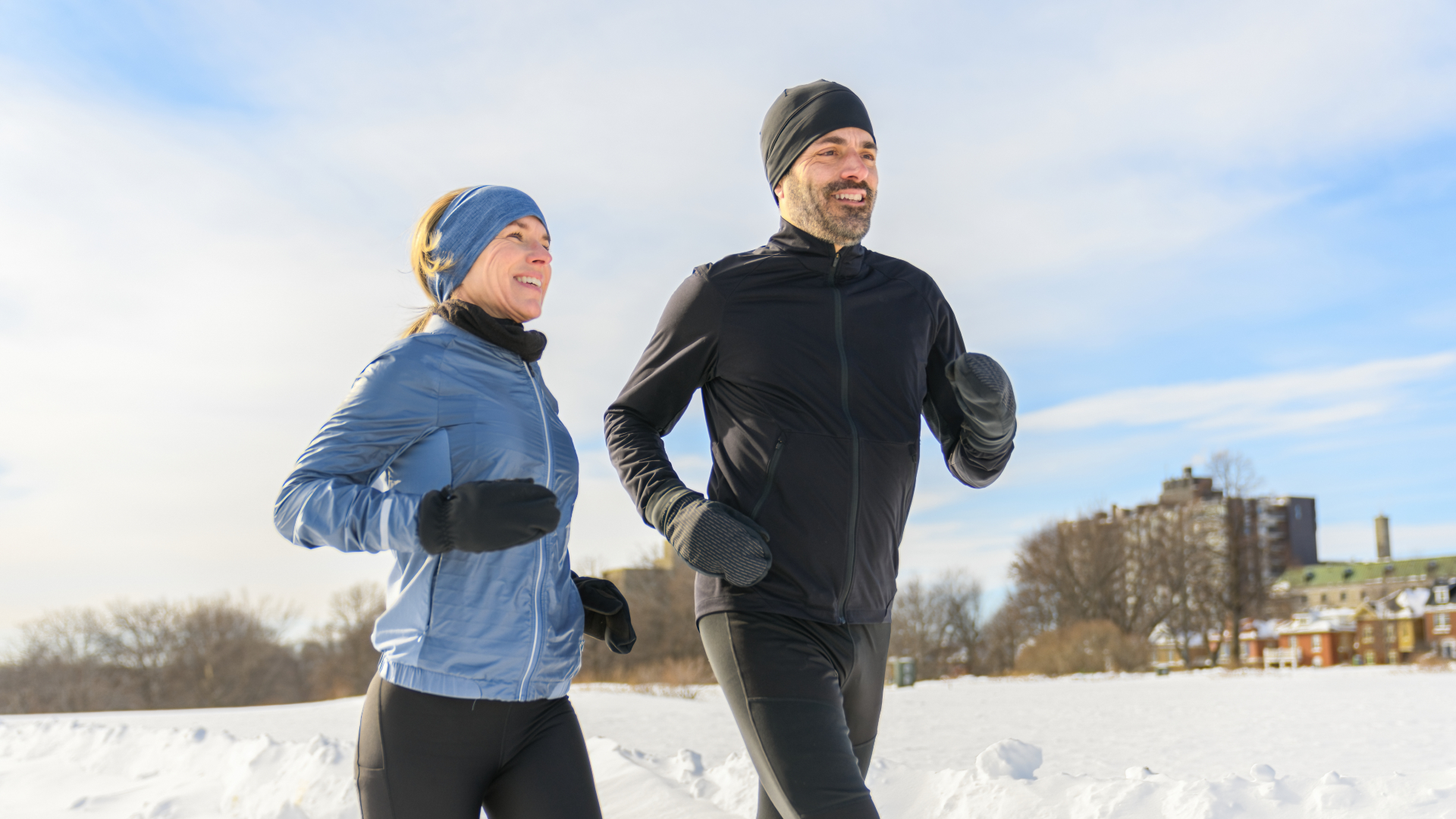 Woman and man running in the snow
