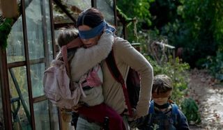 Bird Box Sandra Bullock leading her kids, blindfolded, into a greenhouse