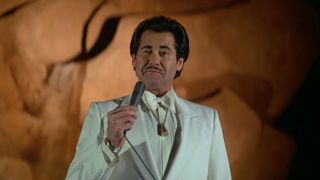 Wayne Newton smiles as he delivers an outdoor sermon in License To Kill.