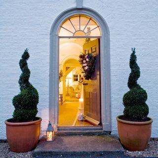house exterior with front door decorations and potted plant