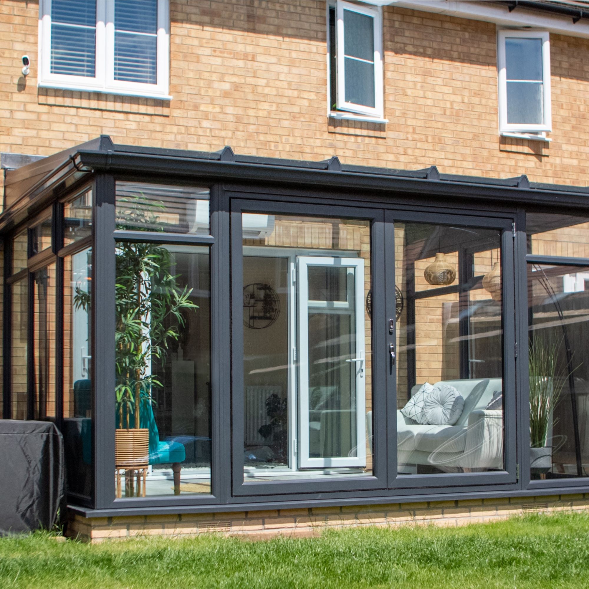 Conservatory on rear of house with glass panels and black frame