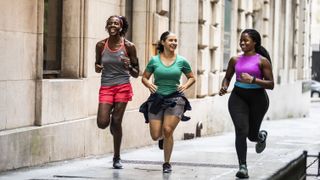 Three women running down street