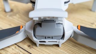 DJI Mini 4K battery compartment open to show the battery at the rear of the drone