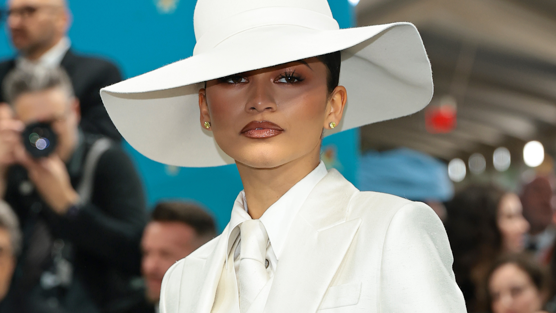Zendaya posed in all bridal white, beginning with a sheer button-down, a peekaboo bra, and the neck tie trend