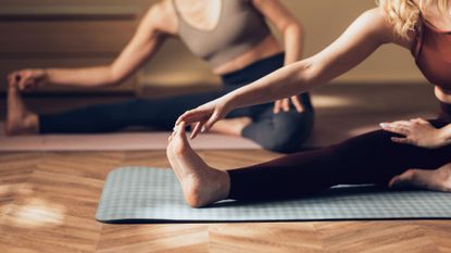 Two women practicing active recovery in studio