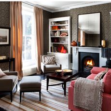 living room with wallpaper on wall armchair and fireplace