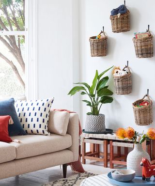 living room with white wall and wall mounted toy baskets
