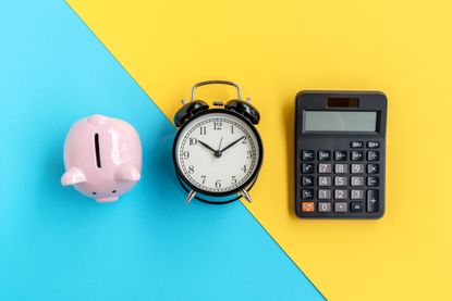 A piggy bank next to a clock and a calculator
