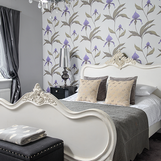 bedroom with floral wallpaper and white bed