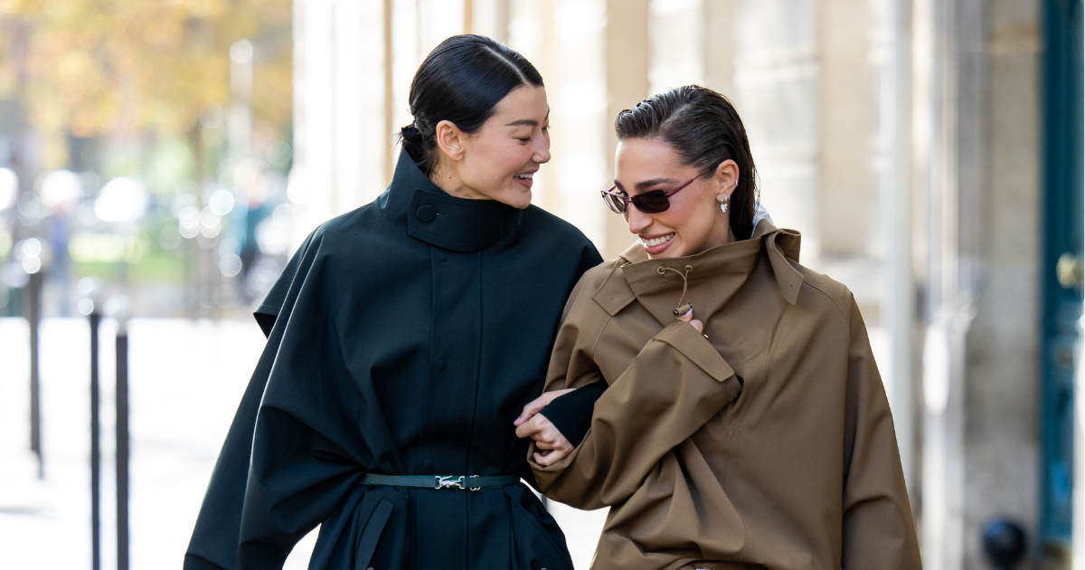 malachite skincare Amalie Gassmann wears black belted coat, blue bag &amp; Ginevra Mavilla wears brown skirt, jacket, silver bag, white heels, sunglasses outside Lacoste during the Womenswear Spring Summer 2026 as part of Paris Fashion Week on October 05, 2025
