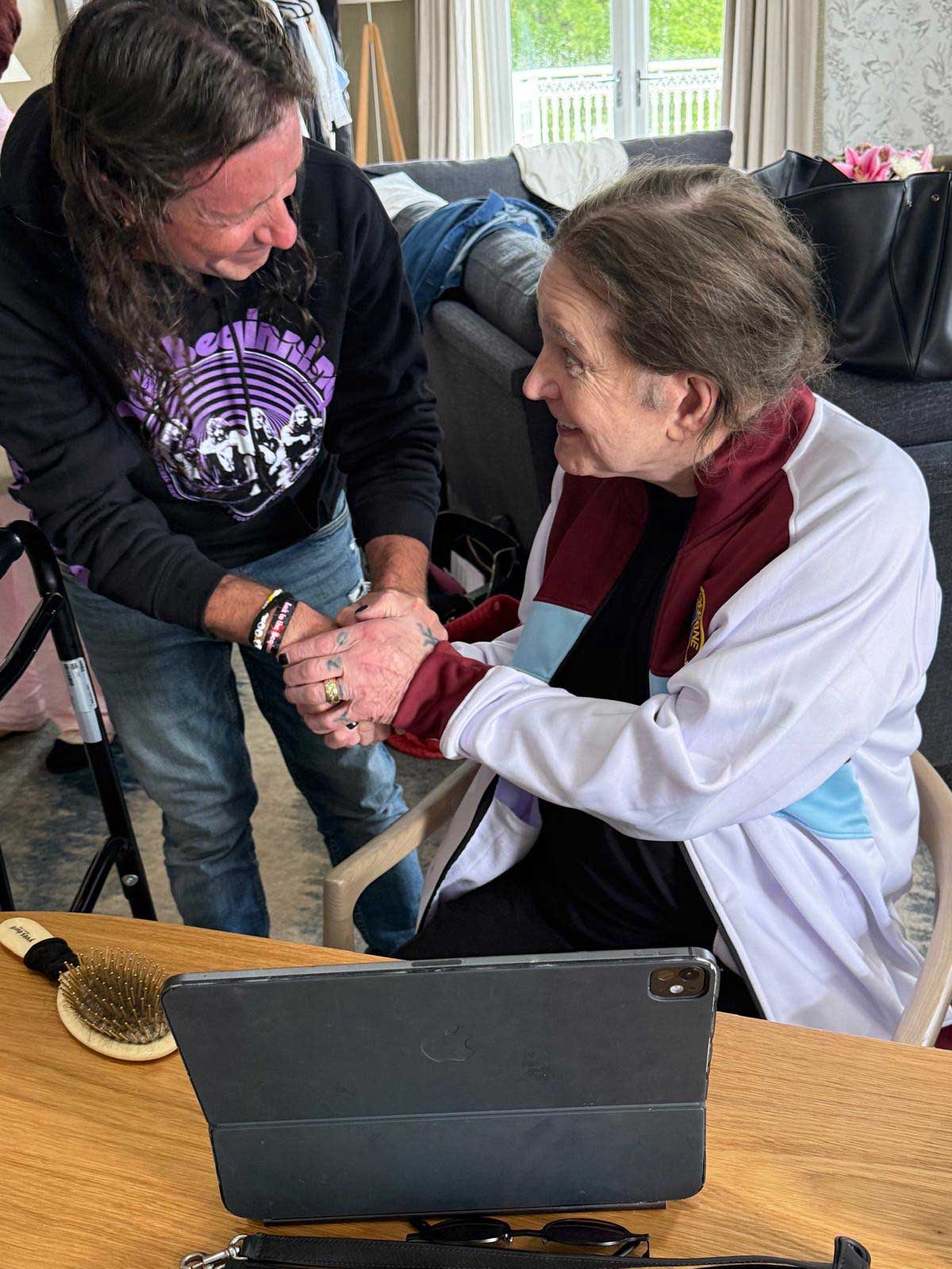 Stephen Rea and Ozzy Osbourne greet each other backstage at the Back To The Beginning show in Birmingham