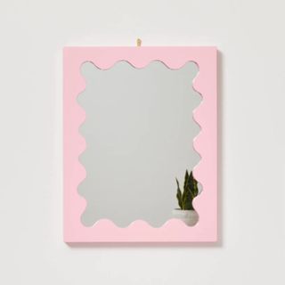 Lola Small Ripple Mirror in pink with plant in reflection