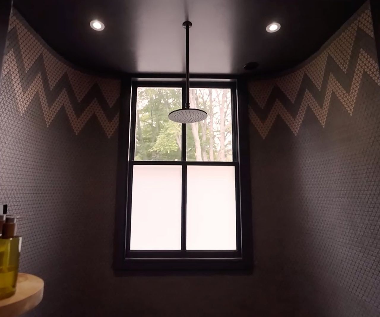 A black bathroom with an overhead shower