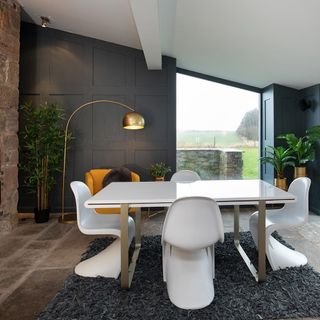 dinning room with white table chair floor lamp and floor rug