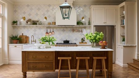 A warm white kitchen with a wooden island and tiles walls