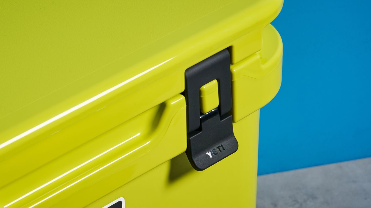the yeti roader cooler in neon yellow with wheels, soft close hinges, a retractable handle, and 32 quart capacity