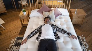 Man lying on a mattress in a store