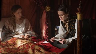 Gentleman Jack – Ann Walker (Sophie Rundle) in bed in a nightdress and shawl and Anne Lister (Suranne Jones) in a dark waistcoat reads a letter 