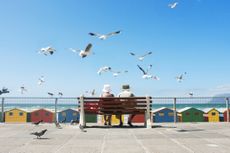 A senior couple enjoy lunch at Muizenberg Beach in Cape Town.