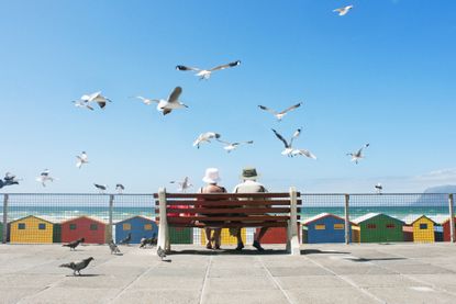 A senior couple enjoy lunch at Muizenberg Beach in Cape Town.
