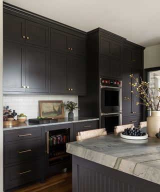 modern kitchen with black Shaker style cabinets and marble island