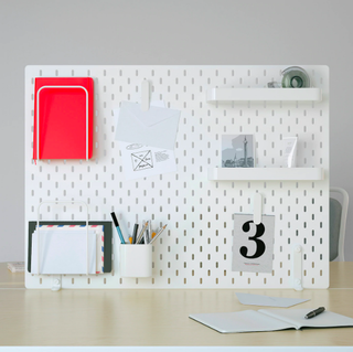 A home office with white modern pegboard