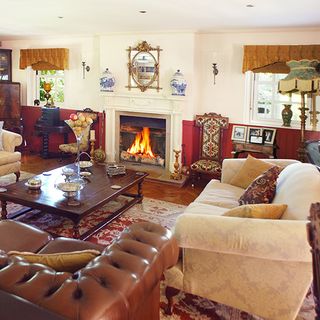 A country living room with comfy sofas, coffee table and real log fire