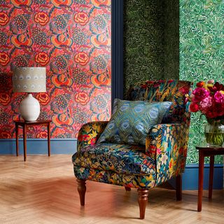 floral wallpaper room with armchair and lamp light