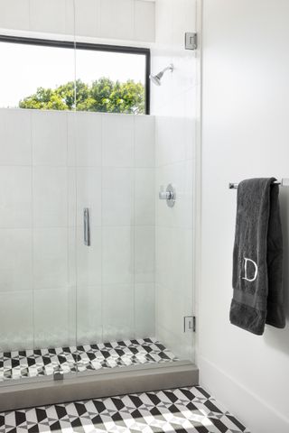 monochromatic shower room with black and white floor tiles