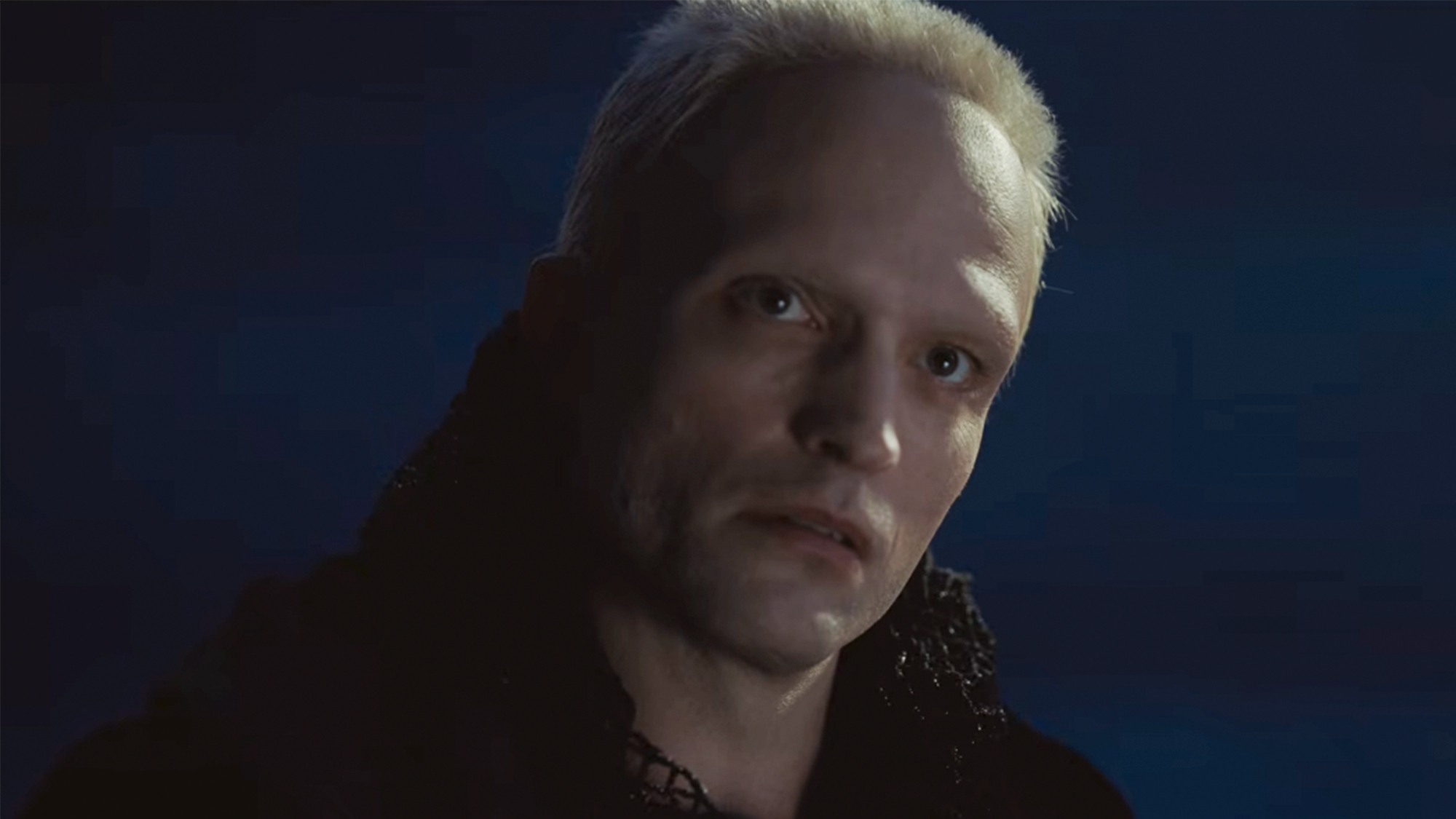 Robert Pattinson with blonde hair in front of a blue background in Dune Part 3