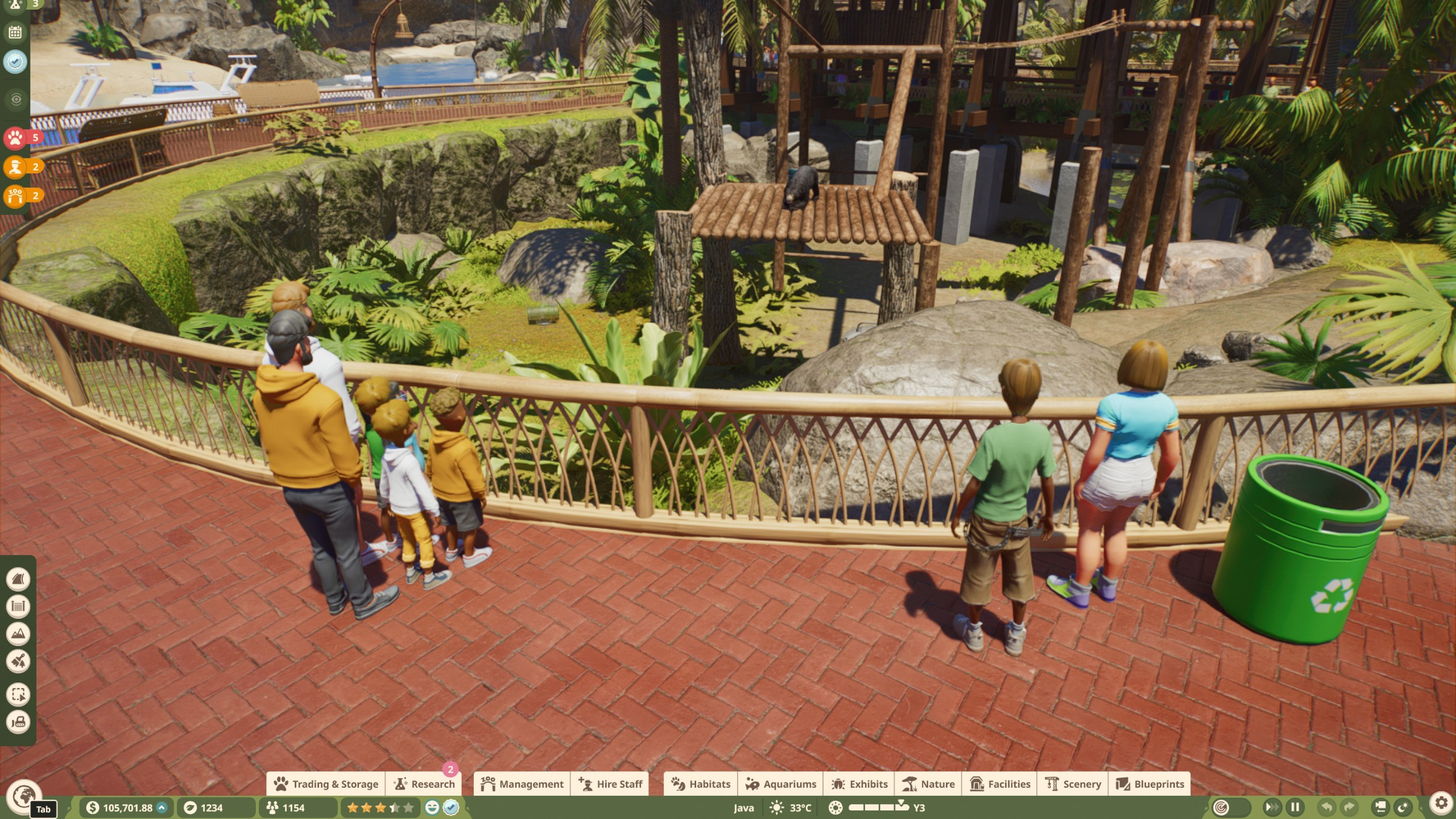 Visitors in a zoo watching a sun bear sat on a viewing platform in Planet Zoo 2.
