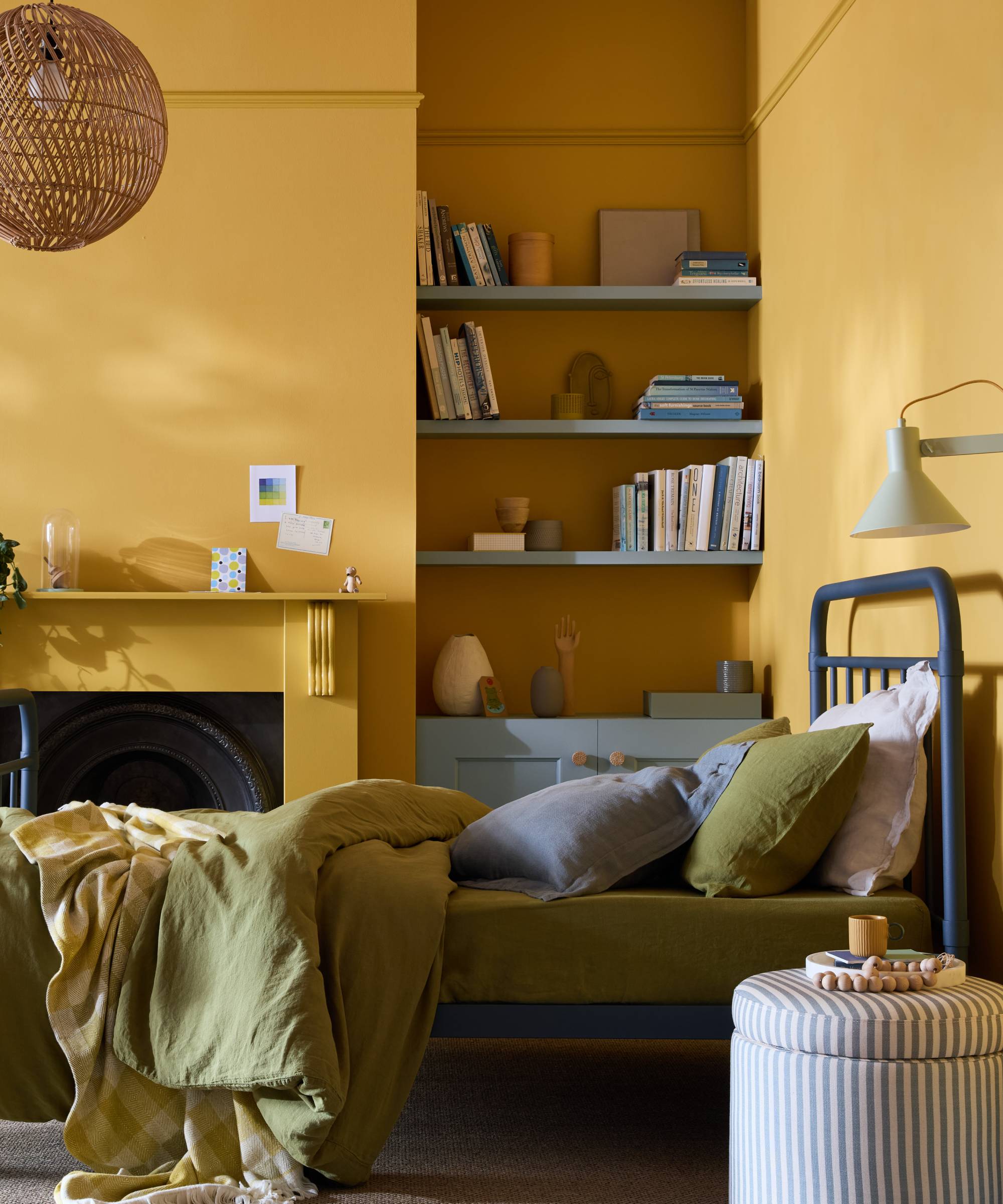 bedroom with yellow walls but blue shelving and cupboard in alcove