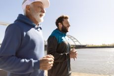 Father and son jogging along a river.