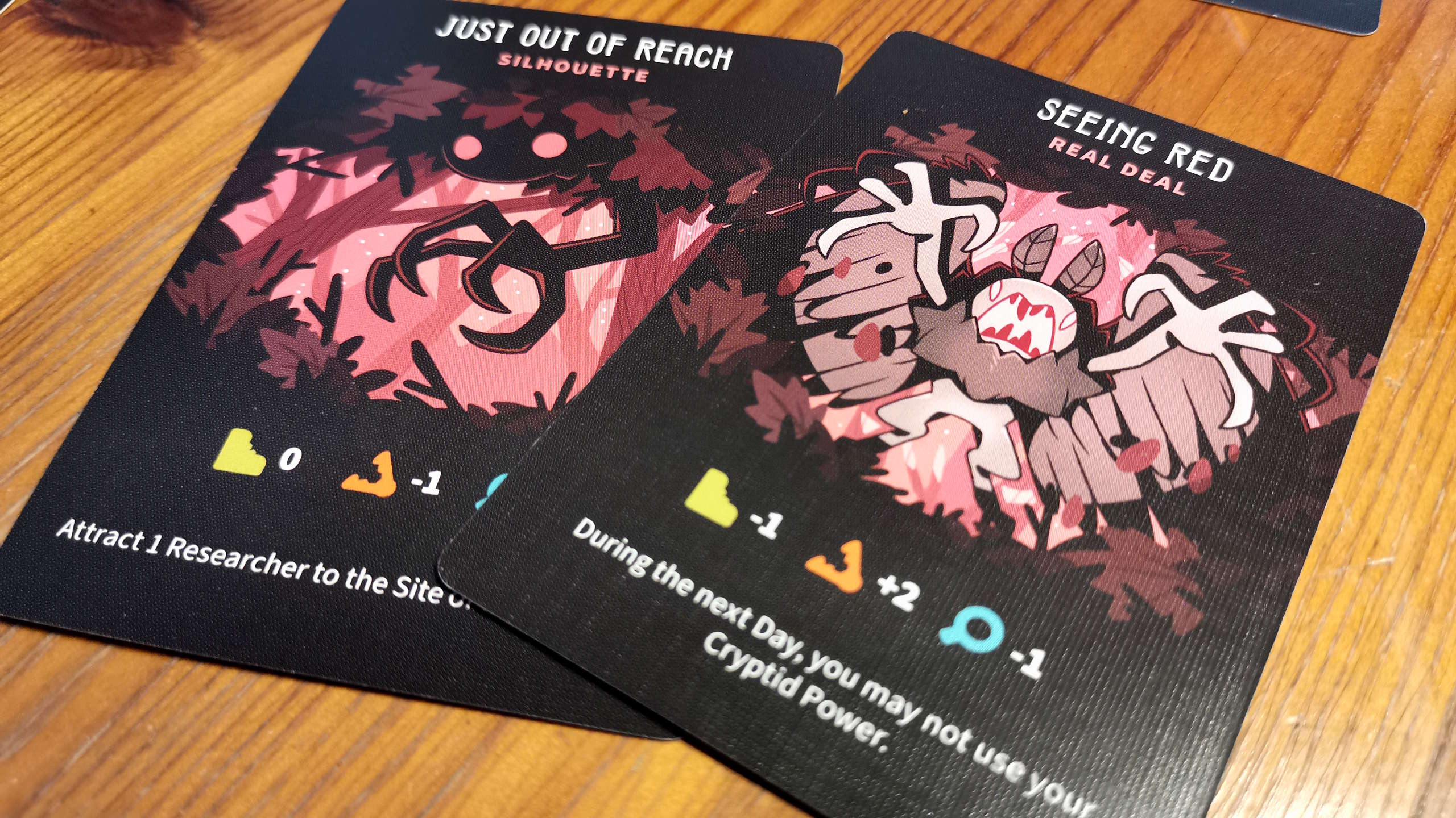 Twisted Cryptids cards on a wooden surface