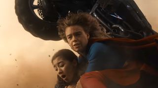 Supergirl holding Ruthye down as motorcycle flies overhead in Supergirl
