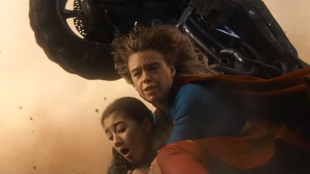 Supergirl holding Ruthye down as motorcycle flies overhead in Supergirl