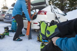 a skier attaches crampons to ski boots