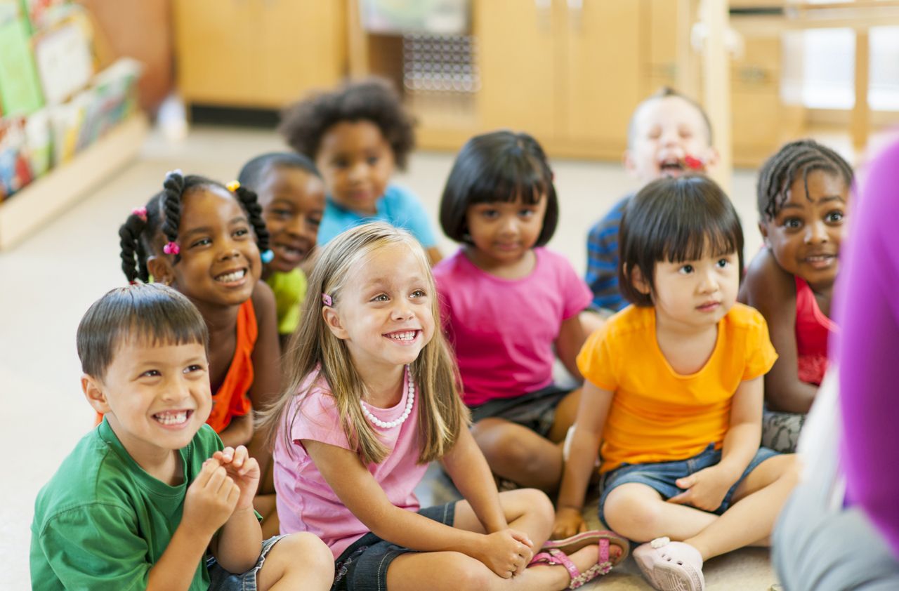 Diverse group of preschoolers listening to a story.