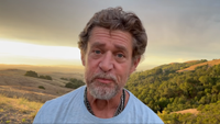 Glen Schofield stands in a large field